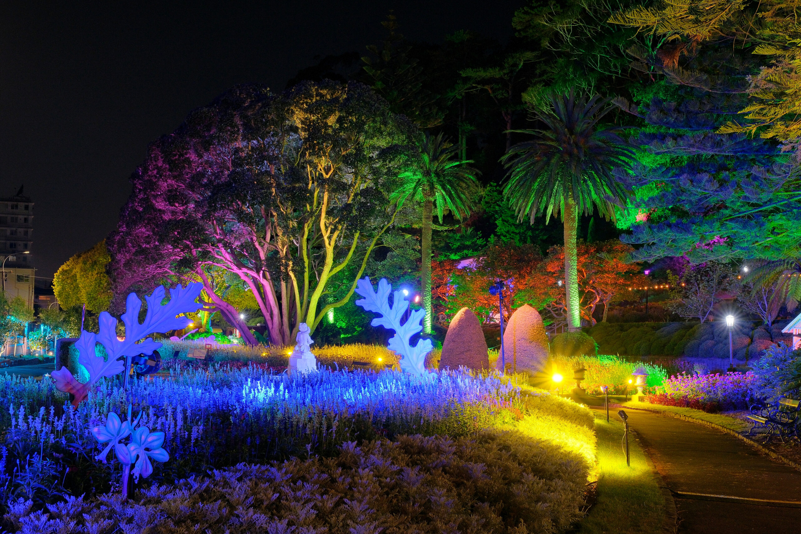 Lit up sculptures in flower garden at night